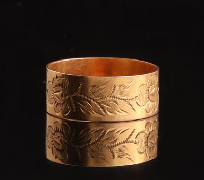 a close up of a gold ring on a black surface
