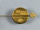 a close up of a gold pin with a arrow on it