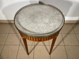 a small table with a glass top on a tiled floor