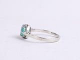 a close up of a ring with a green stone in it
