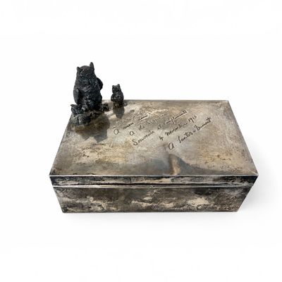 une boîte en argent ornée d'une statue représentant un ours et un chat