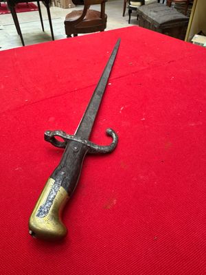 an old sword on a red cloth on a table