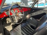 l'intérieur d'une voiture rouge avec des sièges en cuir noir et un volant