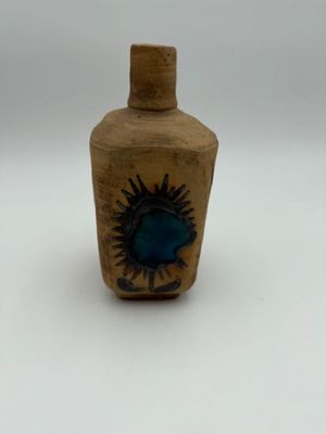 a small bottle with a blue flower on it