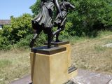 une statue représentant une femme à cheval, posée sur un socle