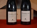 two bottles of wine sitting next to each other on a table