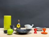 a table with a bowl, vase, and other objects on it