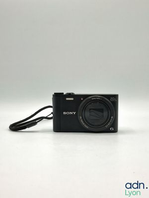 the camera is sitting on a white surface with a cord attached to it
