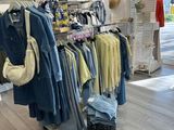 un portemanteau dans un magasin de vêtements, sur lequel sont suspendus des vêtements