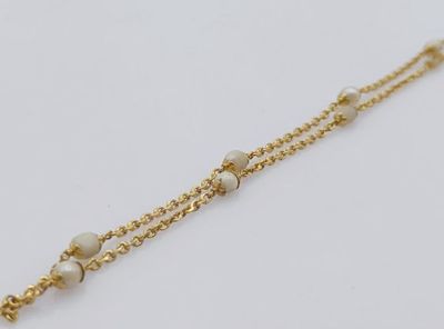 un gros plan d'un bracelet en chaîne dorée orné de perles