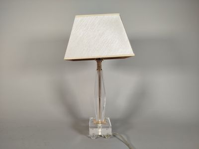 une lampe posée sur une table, avec un abat-jour blanc