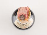 a bottle of wine with a small amount of money inside of it