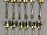six cuillères en argent et deux cuillères en argent posées sur une surface grise
