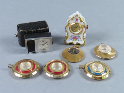 un petit assortiment de montres et d'horloges miniatures posées sur une table