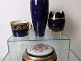 a glass shelf with a blue vase and other items on it