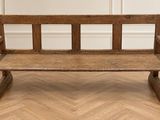 un vieux banc en bois posé sur un parquet en bois dur