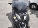 a black motorcycle parked in a parking lot with other vehicles in the background