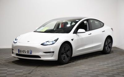 the white tesla model 3 is parked on a checkered floor