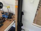 un tuyau noir posé sur une table, à côté d'un ordinateur portable