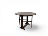 une image représentant une table ronde avec un piètement en bois et un plateau noir