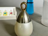 a silver bell sitting next to a blue vase