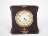 a small clock sitting on top of a brown case