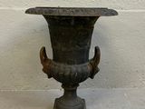 un vase noir posé sur un socle au sol