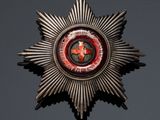 a close up of a metal star with a red and black design on it