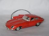 a red toy car that is sitting on a white surface