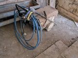 a picture of a hose sitting on the ground next to a piece of wood