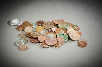 un tas de pièces posé sur une table à côté d'une cuillère