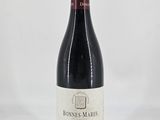 the bottle of wine is sitting on a white surface