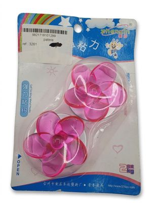 Deux fleurs en plastique roses se trouvent dans un emballage sur fond blanc