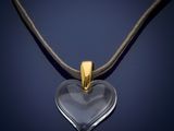 a heart shaped glass pendant on a black cord necklace