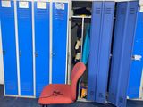 a red chair in a room with blue lockers