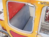 a yellow and red carriage with a red seat and a black seat