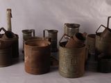 a lot of old metal containers sitting on a table