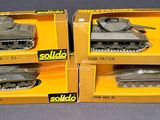 three boxed boxes of toy tanks on a table with a black background