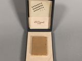 a gold plated cigarette case with a small cigarette in it
