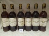 six bottles of wine are lined up in a row on a table