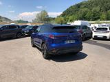 a blue car parked in a parking lot next to other cars