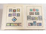 un livre ouvert, orné de timbres, posé sur une surface blanche