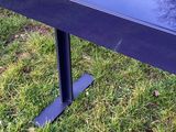 un gros plan sur un banc en métal noir posé dans l'herbe
