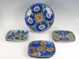 several plates and trays are sitting on a white surface