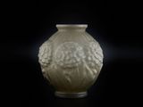 un vase blanc orné d'un visage, posé sur une table