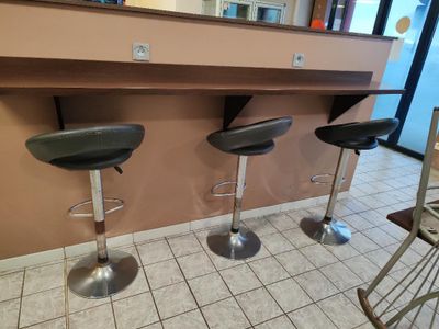 three bar stools sitting in front of a counter