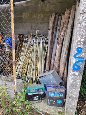un tas de bois et d'autres objets devant une clôture