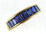 a close up of a gold ring with blue sapphire stones