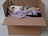 une boîte en carton contenant une pile de vêtements