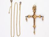 deux croix en or et une chaîne sur un fond blanc
